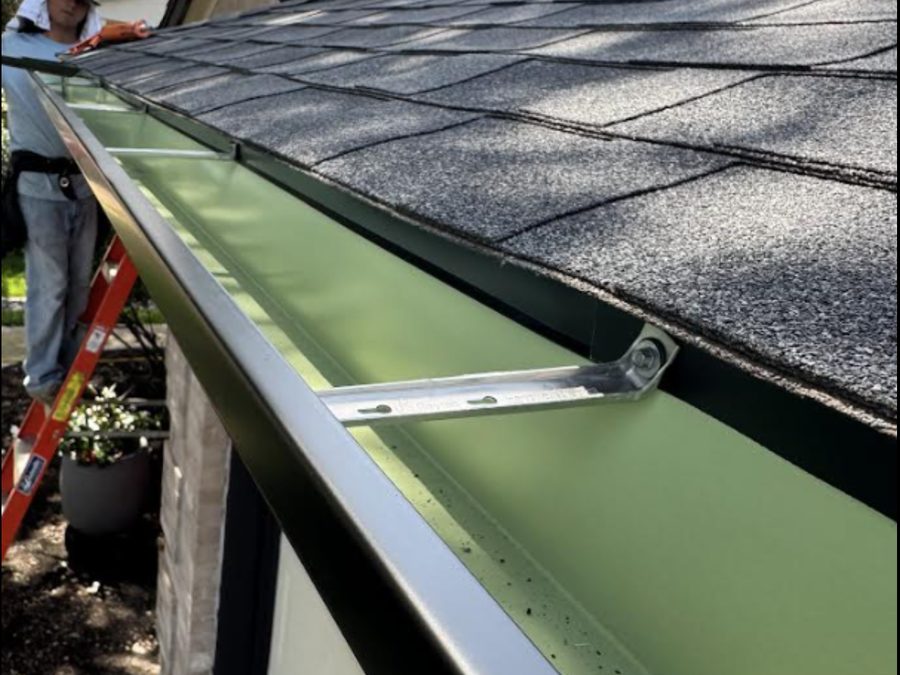 Close-up gutter installation detail along a shingle roofline.